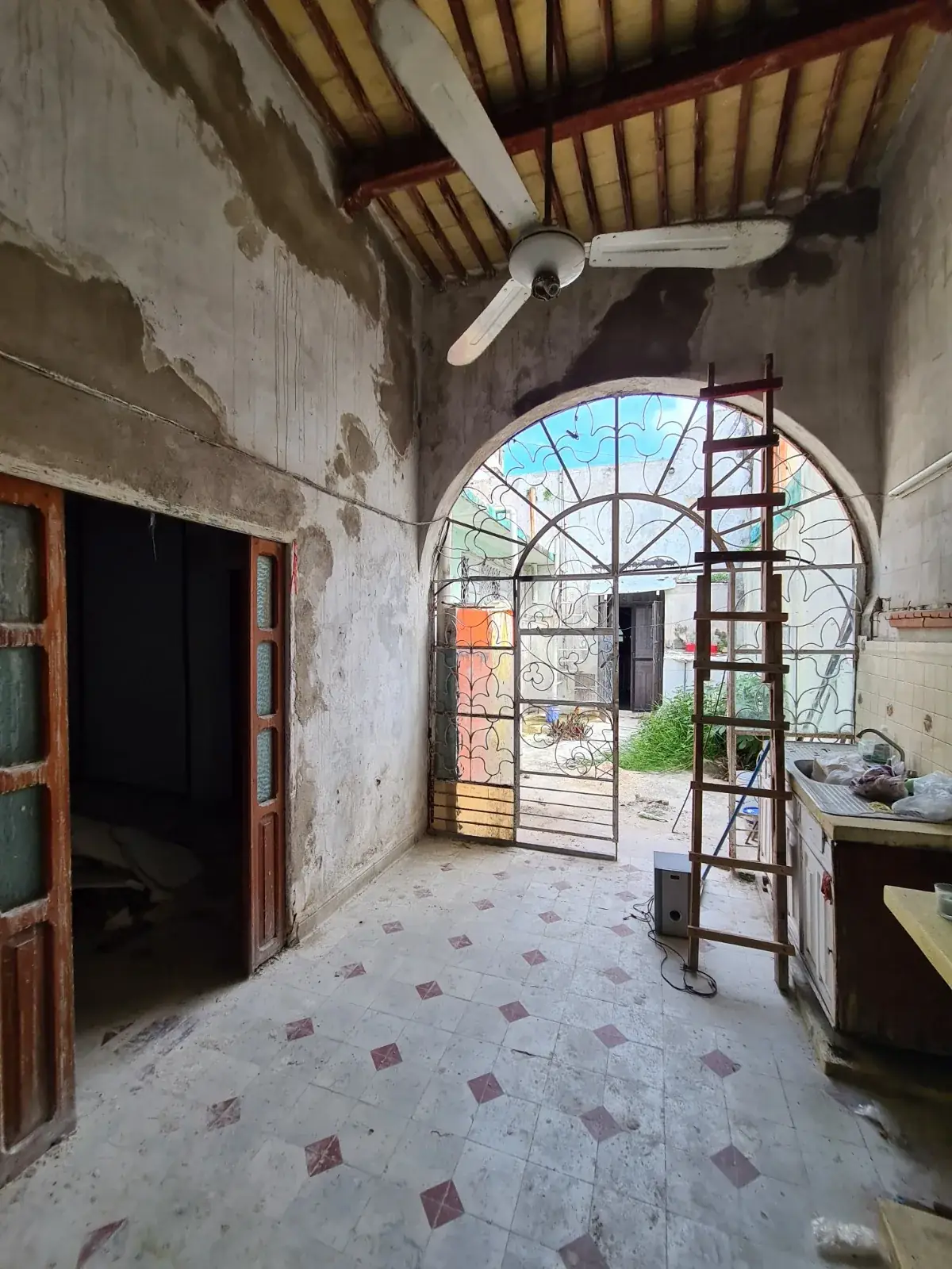 Interior de Casa Ex Templo antes de la restauración: arco de medio punto con andamios y piso de pasta