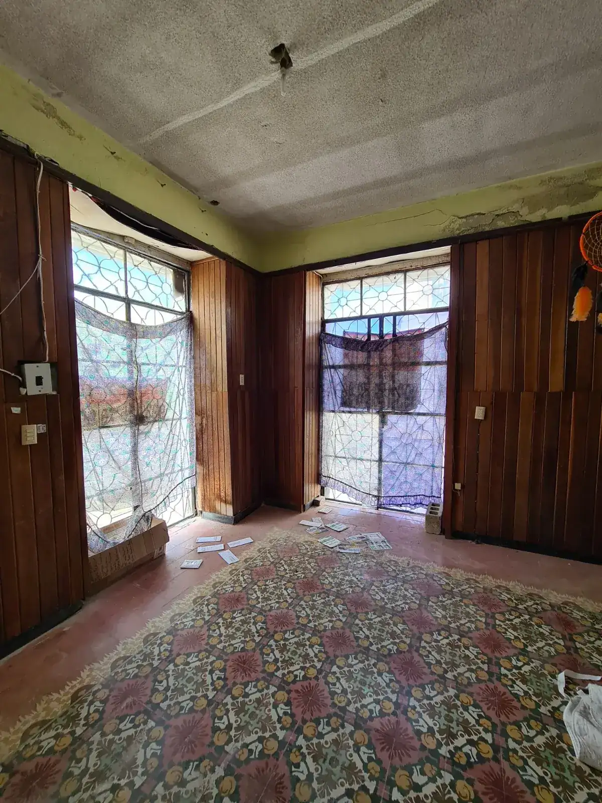 Sala de Casa Ex Templo antes de la restauración, con el piso de pasta bajo recubrimientos de madera