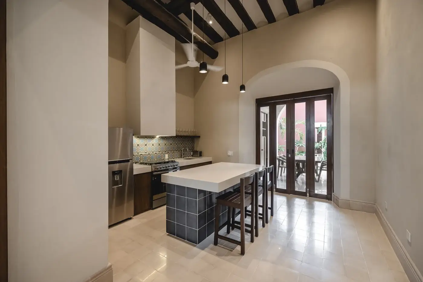 Cocina restaurada de Casa Ex Templo con isla central y vigas de madera