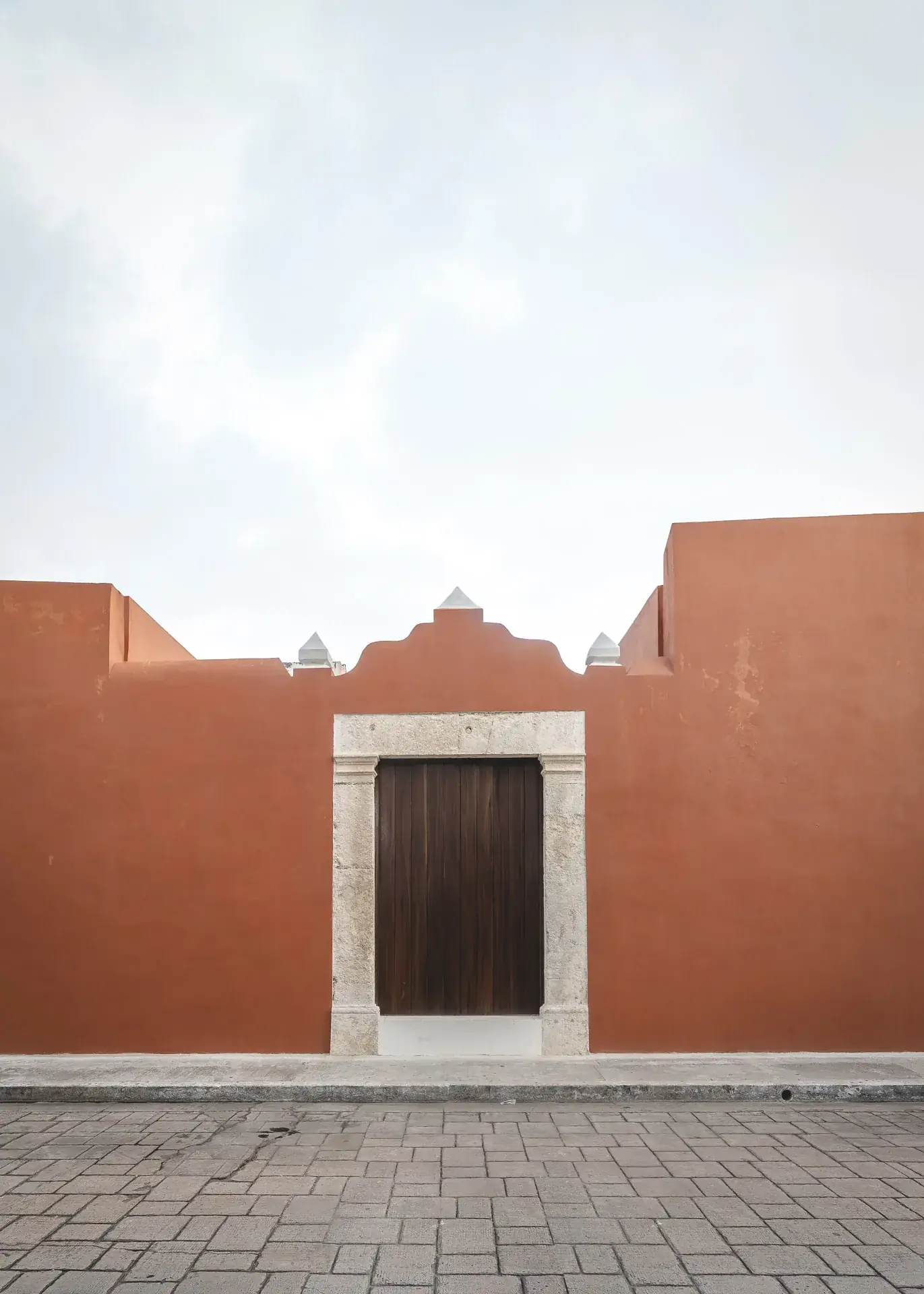 Fachada terracota restaurada de Casa Ex Templo con marco de piedra, ciudad amurallada de Campeche