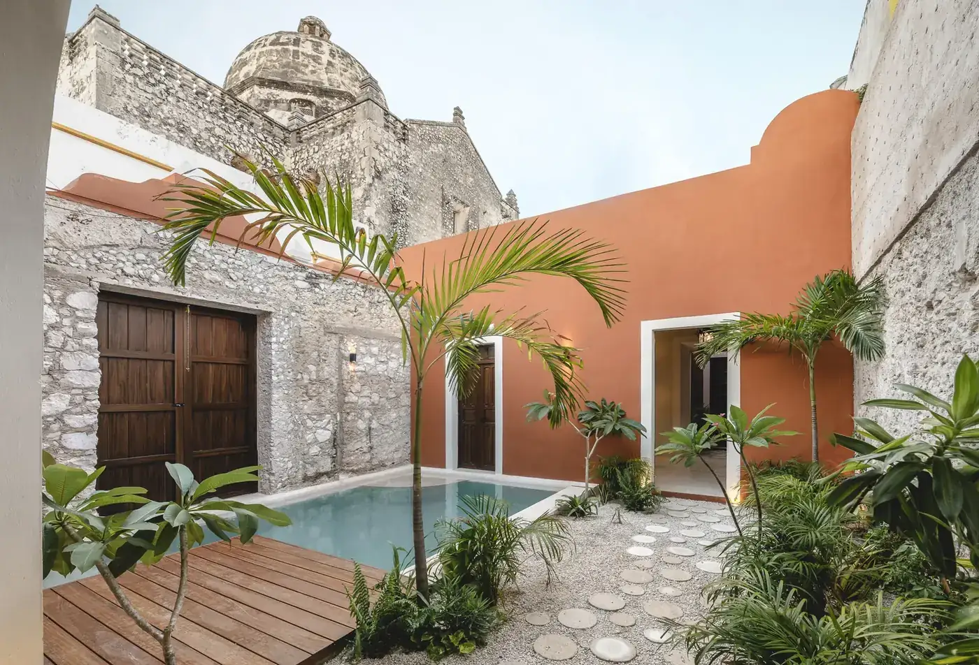 Restored courtyard of Casa Ex Templo with chukum pool and the dome of the former San José temple, Campeche. Casonas MX