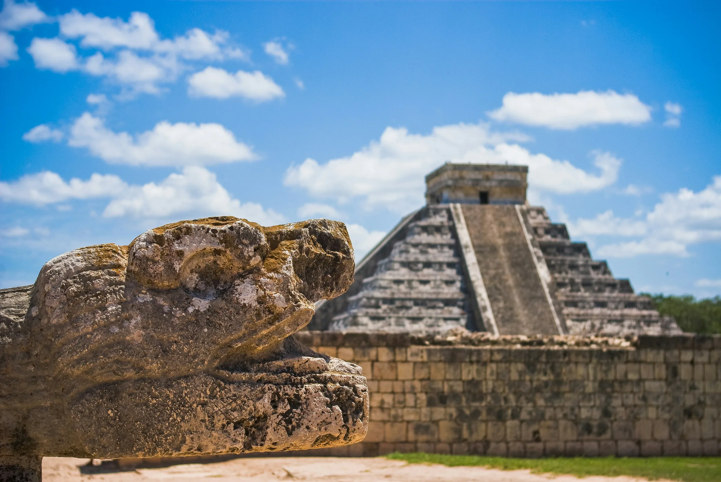 El Castillo at Chichén Itzá behind a carved stone serpent head, the first major stop on the route