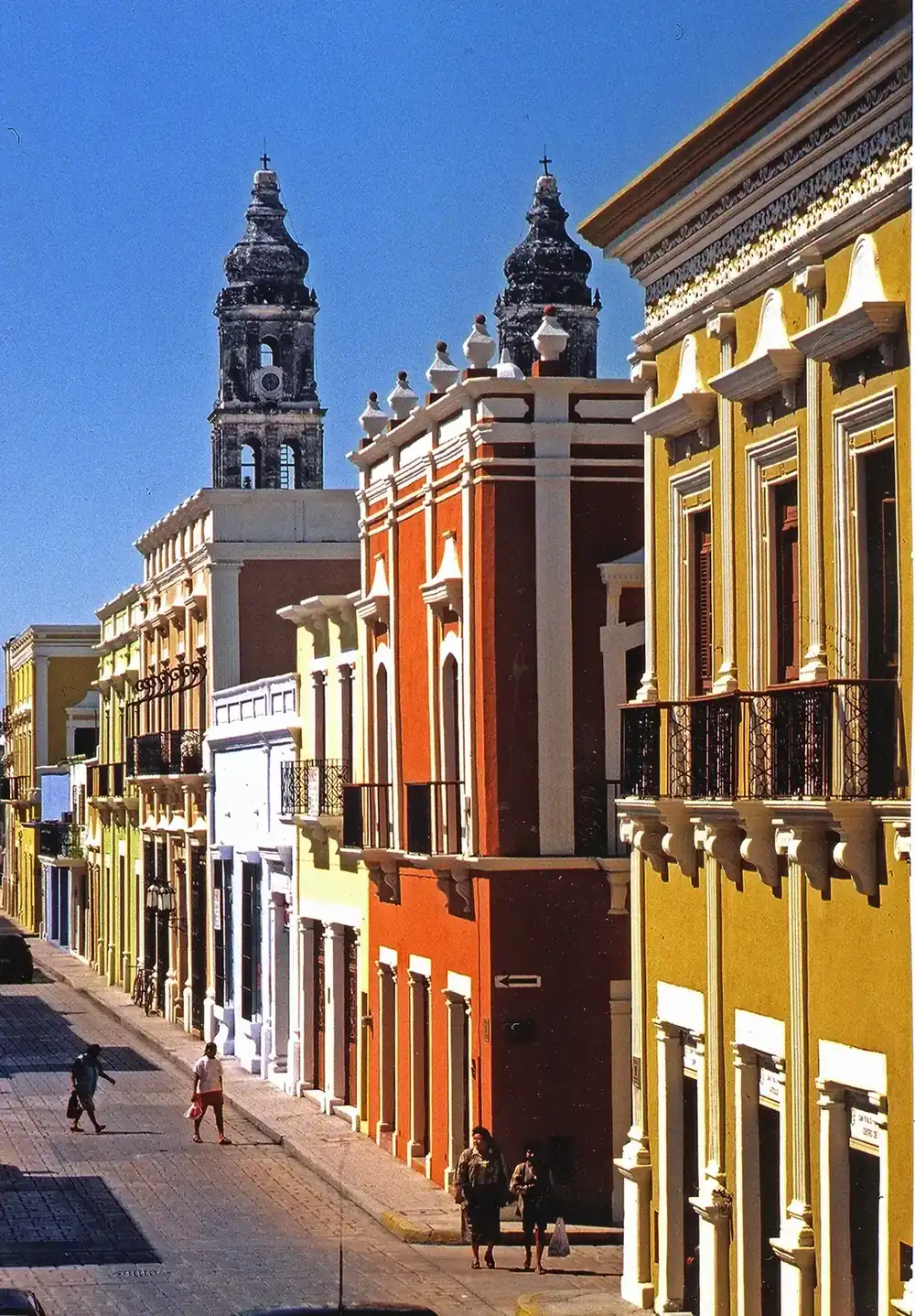 Calle del centro histórico de Campeche con fachadas de colores y las torres de la Catedral