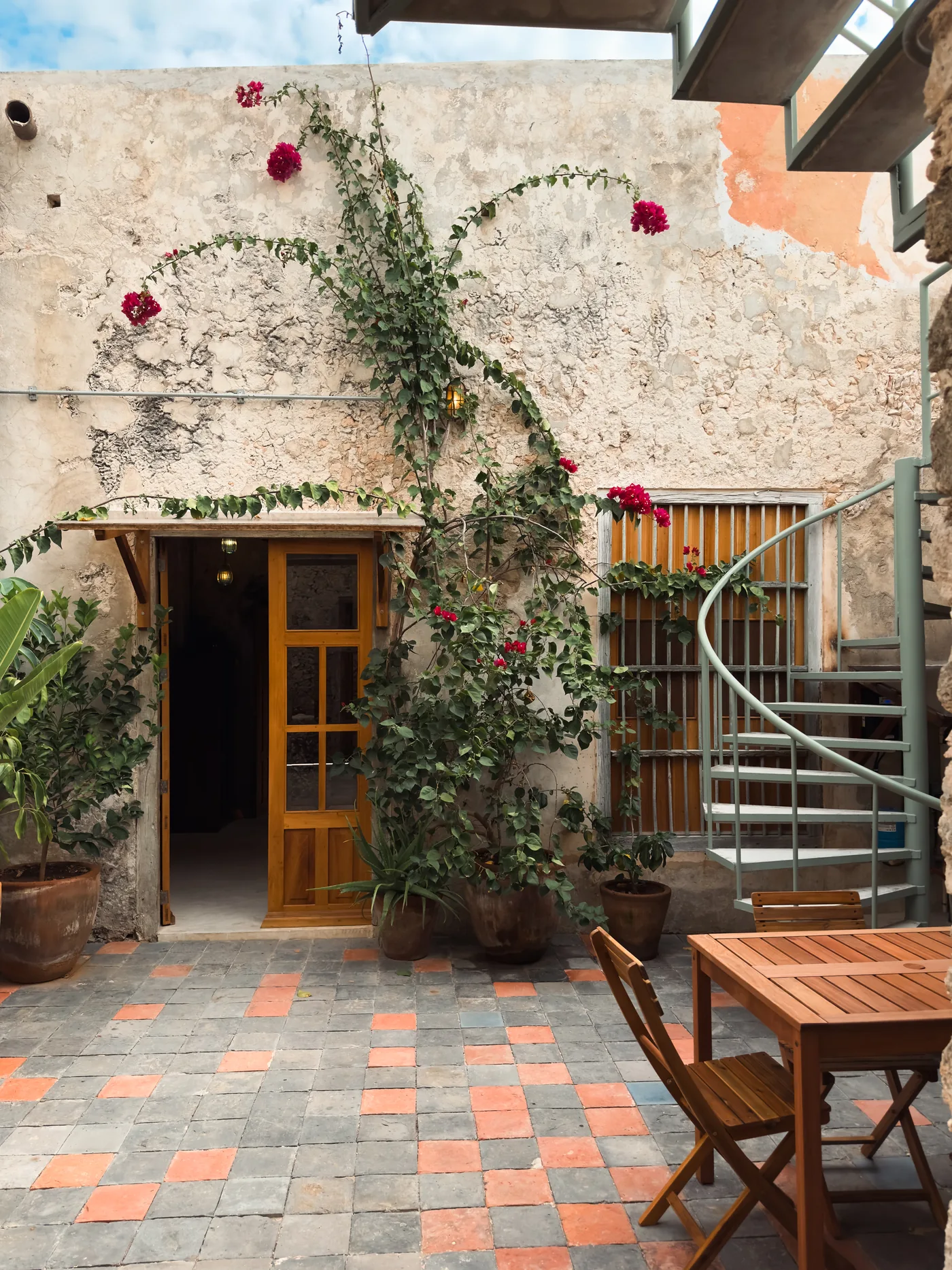 Courtyard of a restored casona in Campeche with bougainvillea, stone walls and cement tile floor